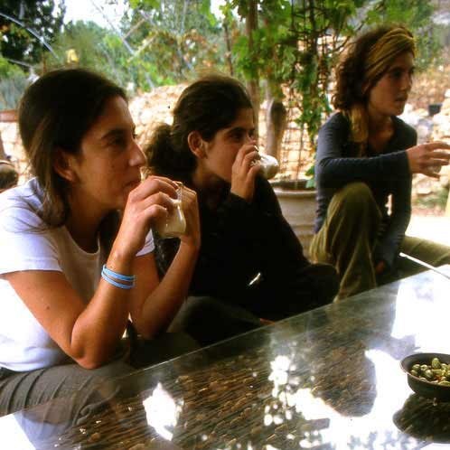 Volunteers drinking chai tea at Goats with the Wind farm – Galilee, Israel. Photography by Tal Gluck.